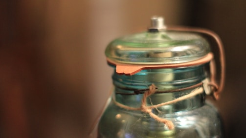 Close-up of a custom glass jar with embossed logo and decorative patterns