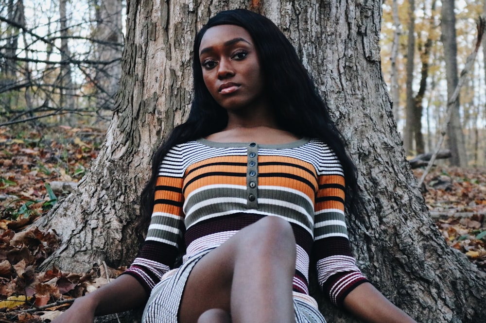 woman wearing striped shirt laying near tree