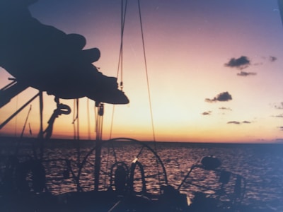 A beautiful sunset over the ocean with a yacht silhouette.
