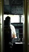 A professional pilot reviewing flight plans inside a modern cockpit.