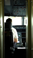 Professional pilot reviewing flight plans inside a modern aircraft cockpit.