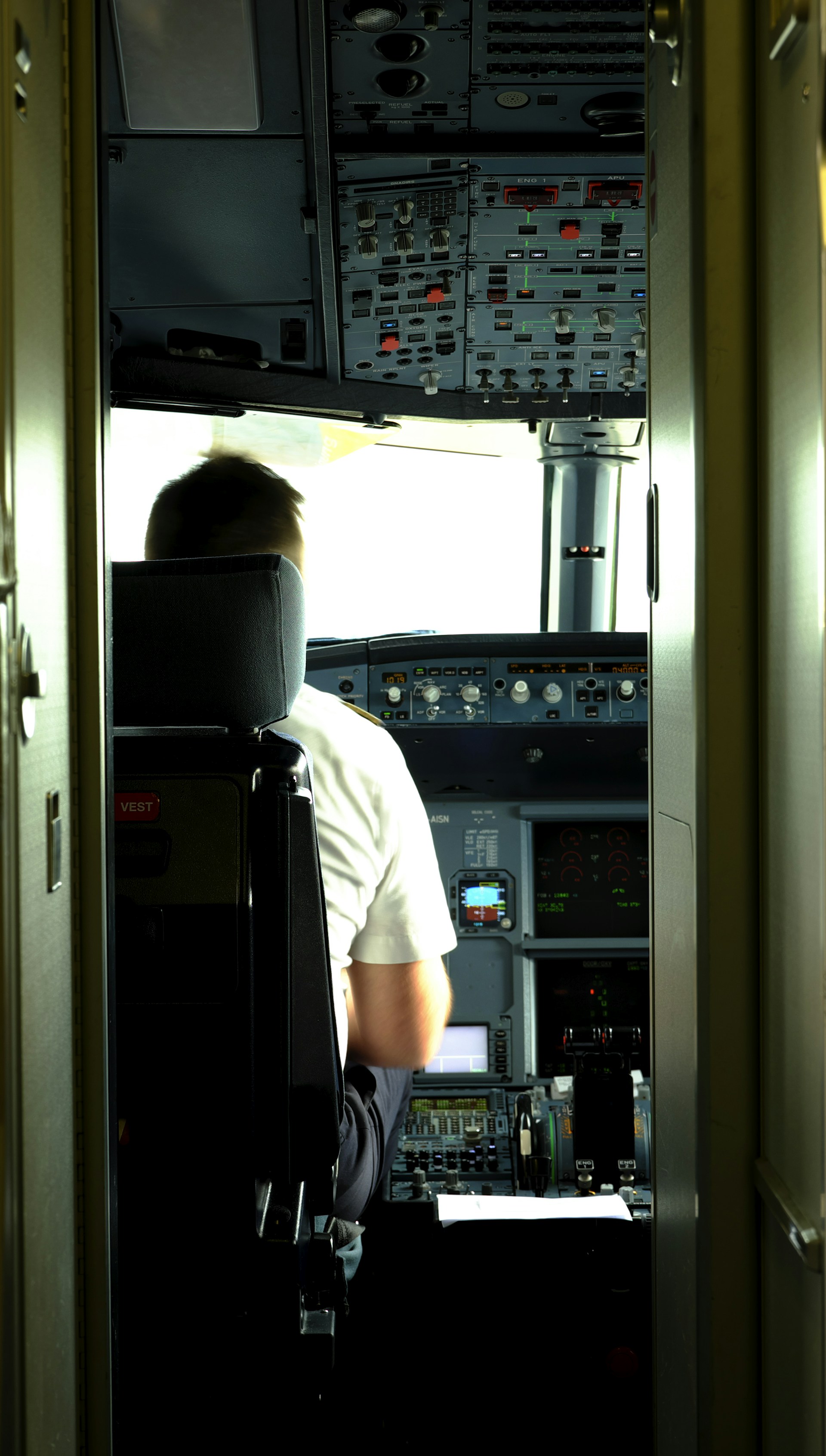 Close-up of a pilot smiling inside the cockpit of an ultralight, with sunlight reflecting off the instrument panel.