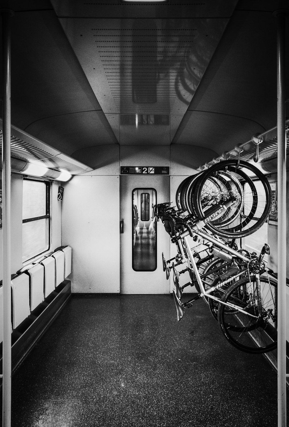 grayscale photo of bikes on rack