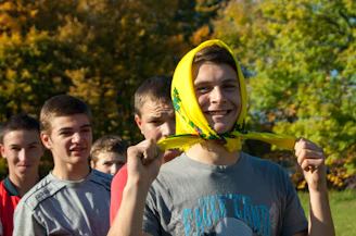 A group of young people engaged in community service, smiling and working together outdoors.