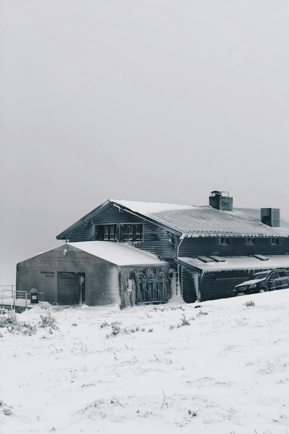 blau-weißes Holzhaus mit Schnee bedeckt
