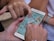 A smartphone displaying a digital map is being held by a hand, while another hand points to a specific location on the screen. Additional hands are partially visible, suggesting collaborative navigation or decision-making.