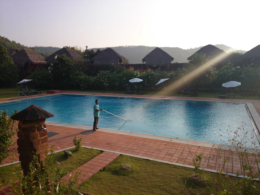 Technician cleaning a pool with a telescoping pole