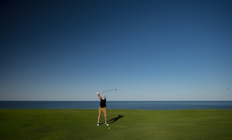 man standing on green grass field playing golf