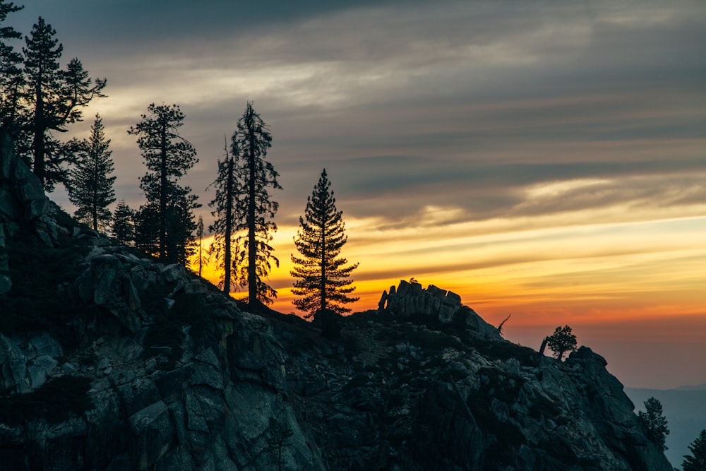 the sun is setting on a rocky mountain