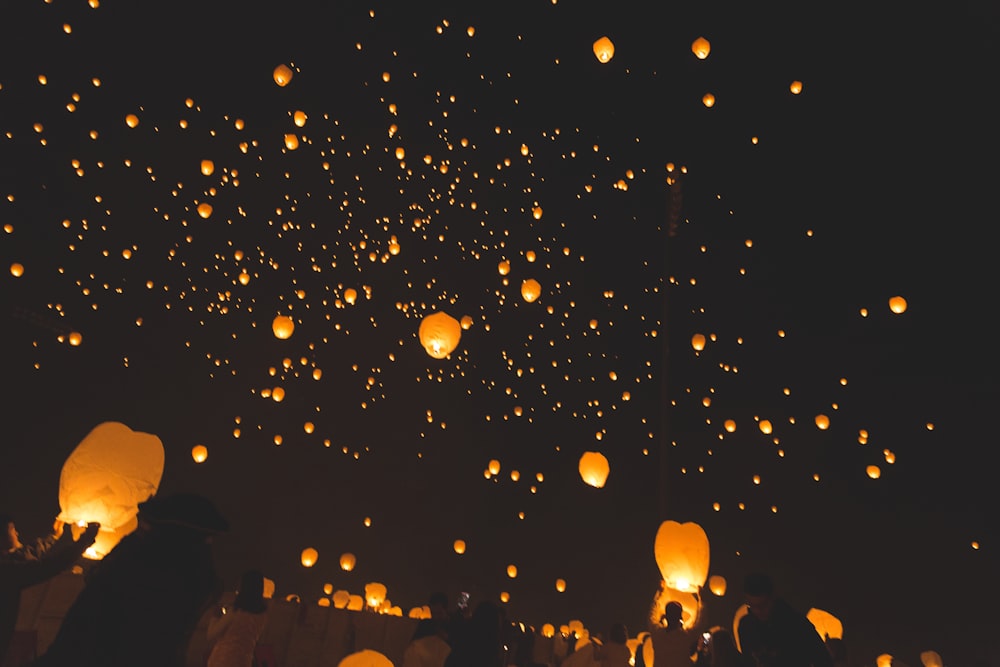 pessoas levantando lanternas do céu