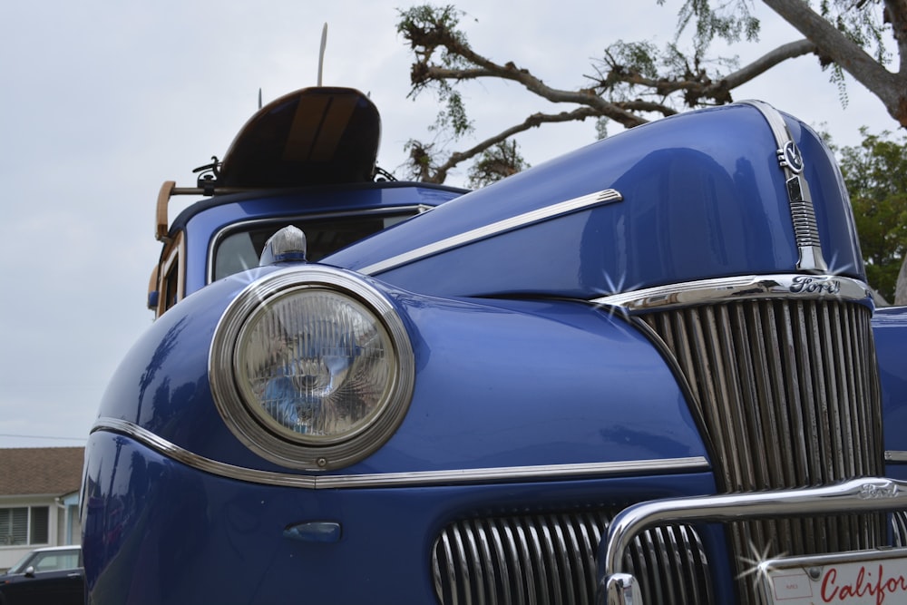 low-angle photo of classic blue vehicle during daytime