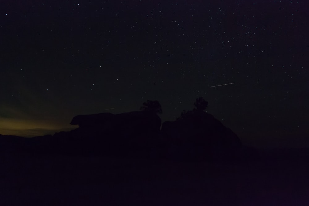 Il cielo notturno con le stelle sopra una formazione rocciosa