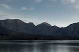 A serene lake reflecting snow-capped peaks in the early morning light.