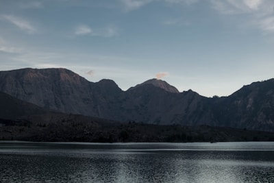 A serene lake reflecting snow-capped peaks in the early morning light.