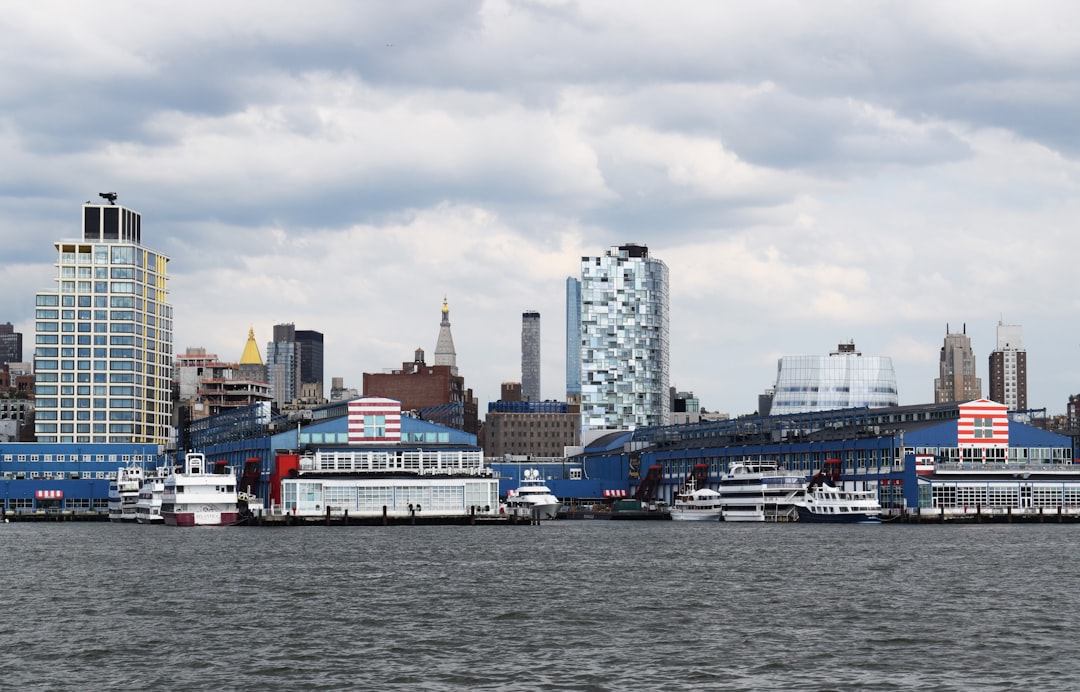 white and black ship on sea near city buildings during daytime