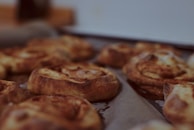 Freshly baked cinnamon rolls cooling on a rack with soft morning light.