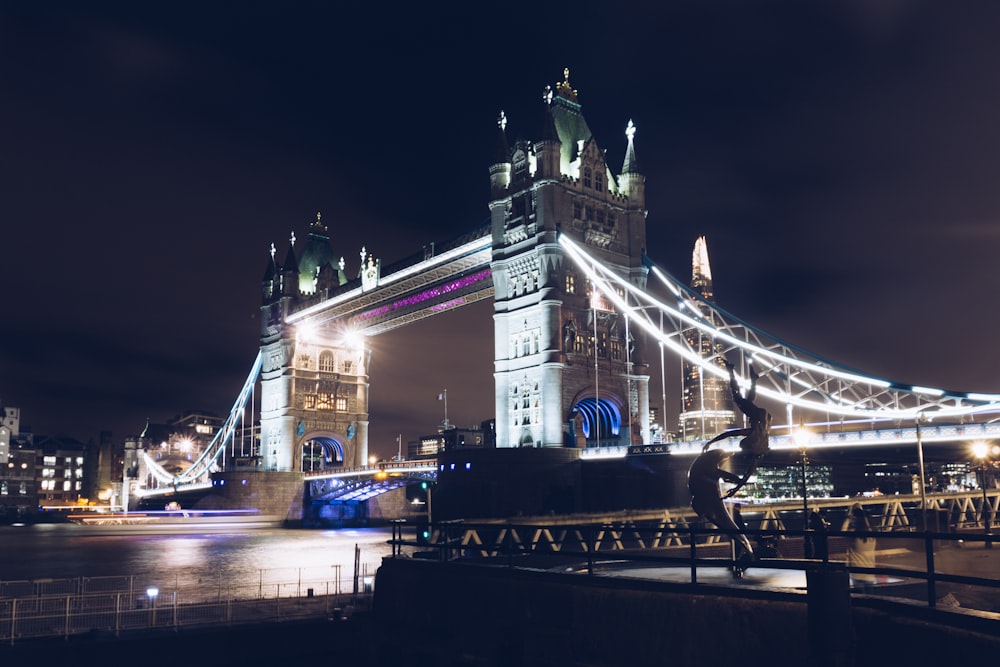 man in blue denim jeans jumping over bridge during night time