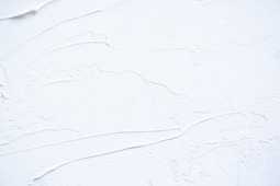 a close up of a white wall with peeling paint