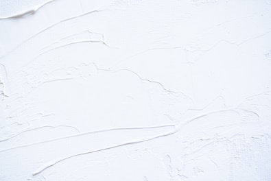 a close up of a white wall with peeling paint