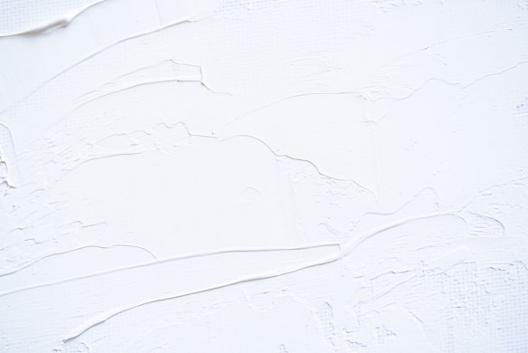 a close up of a white wall with peeling paint
