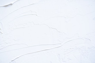 a close up of a white wall with peeling paint