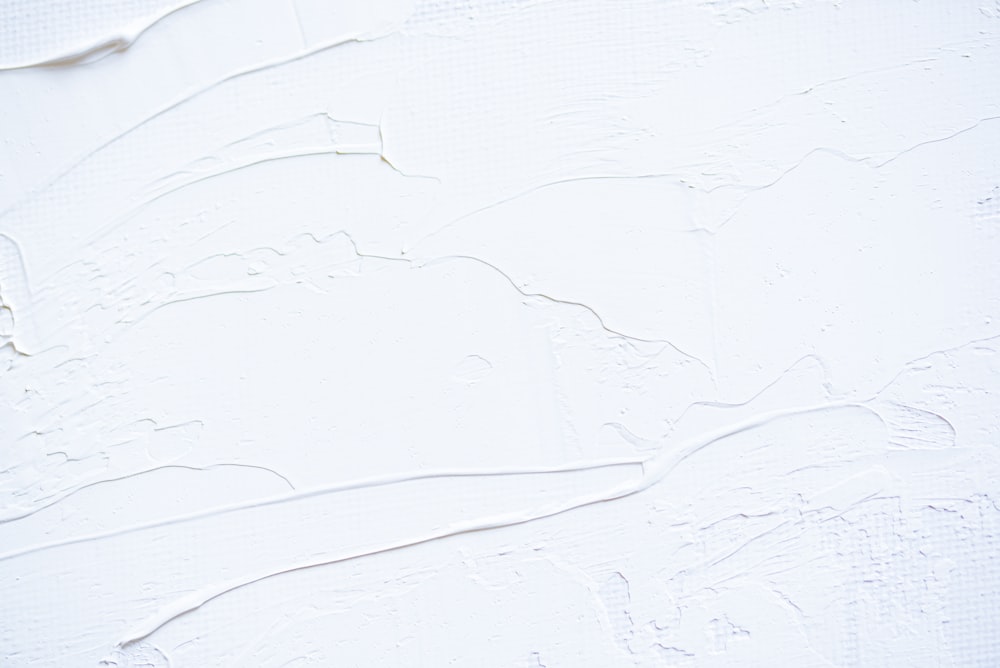 a close up of a white wall with peeling paint