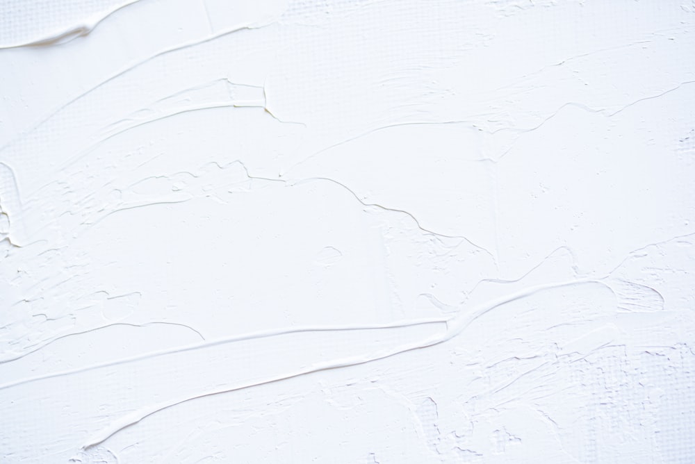 Un primer plano de una pared blanca con pintura descascarada