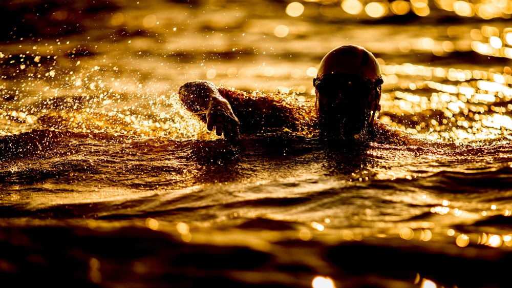 person swimming on body of water at nighttime