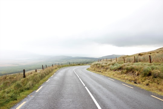 gray asphalt road near grass under gray sky during daytime in Connor Pass Ireland