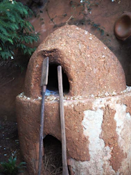 Traditional wood-fired oven next to kayaks ready for a peaceful river adventure.