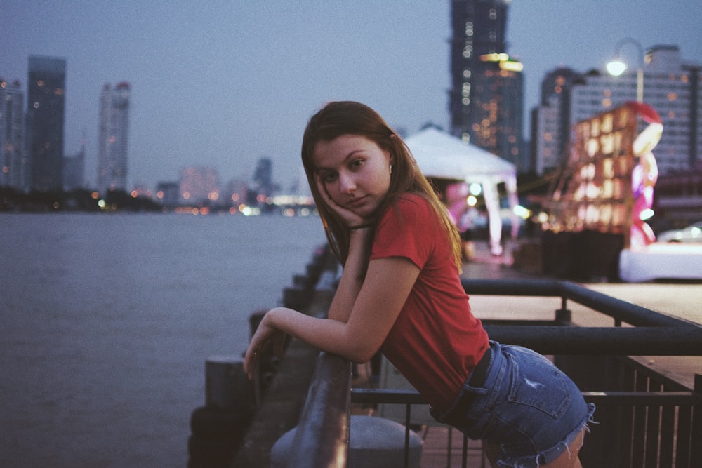 woman standing in front of the fence resting her arms