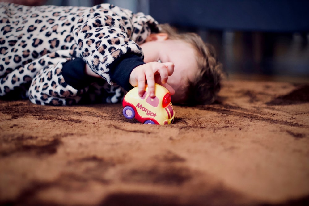 baby playing yellow toy car