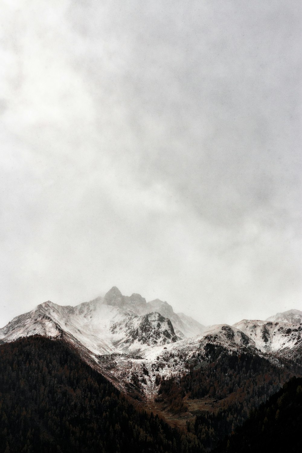 montagna ghiacciata del cappuccio sotto il cielo grigio durante la fotografia diurna