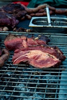 Close-up of a sizzling parrilla grill with assorted meats cooking over glowing coals