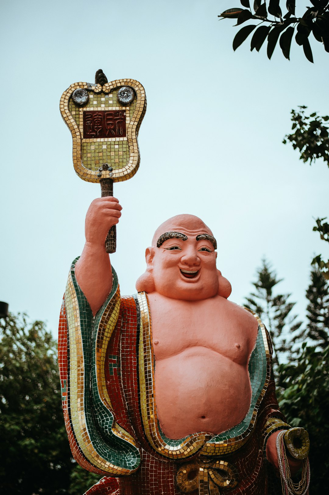 Budai statue surround green tress