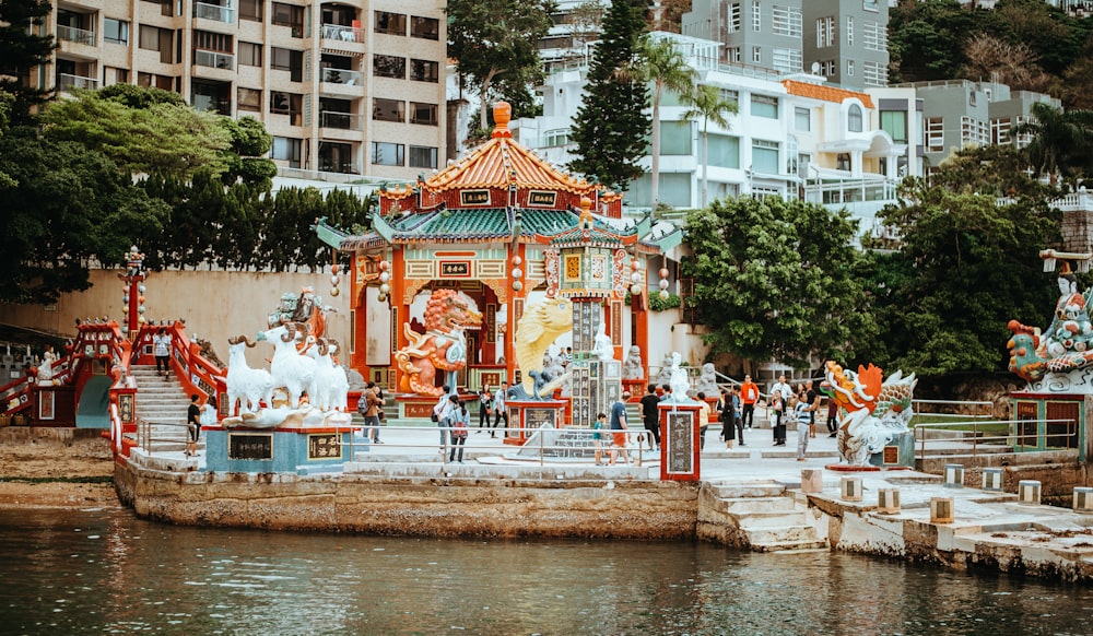 orange and blue concrete pagoda near body of water