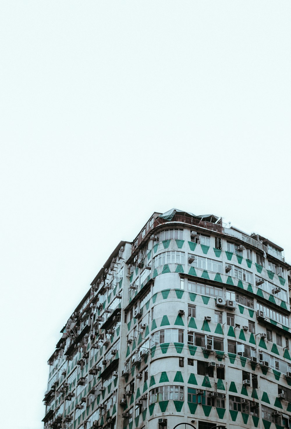 昼間の白と緑のコンクリートの建物のローアングル撮影