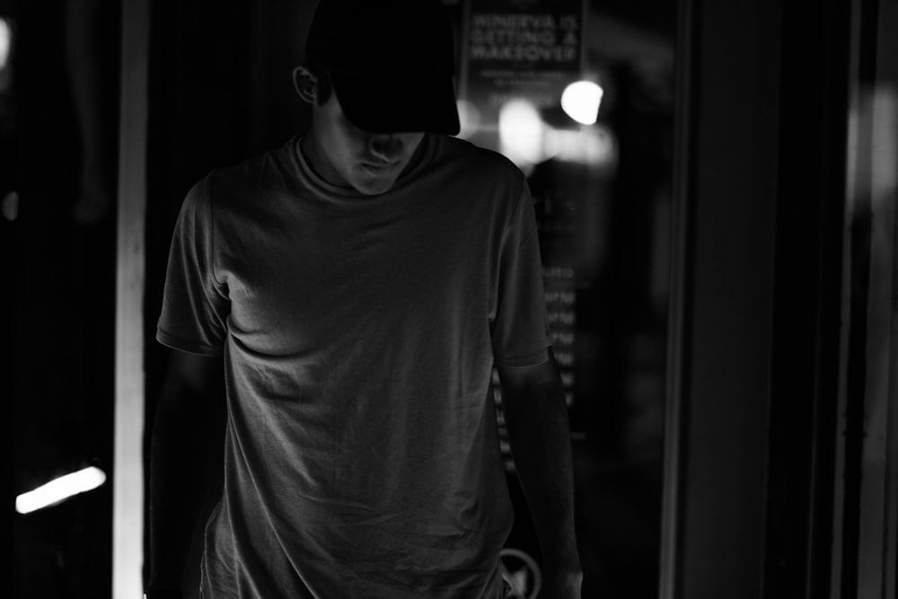 gray scale photography of man wearing crew-neck shirt and trucker hat