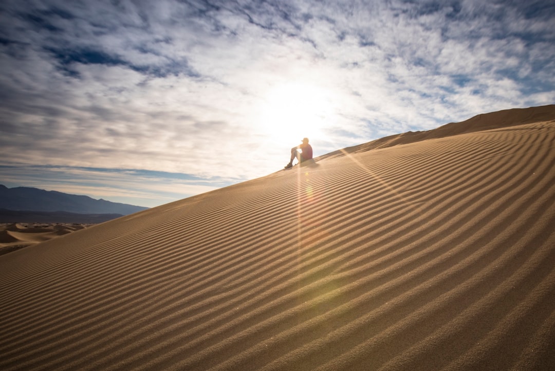 person sitting on desert during daytime