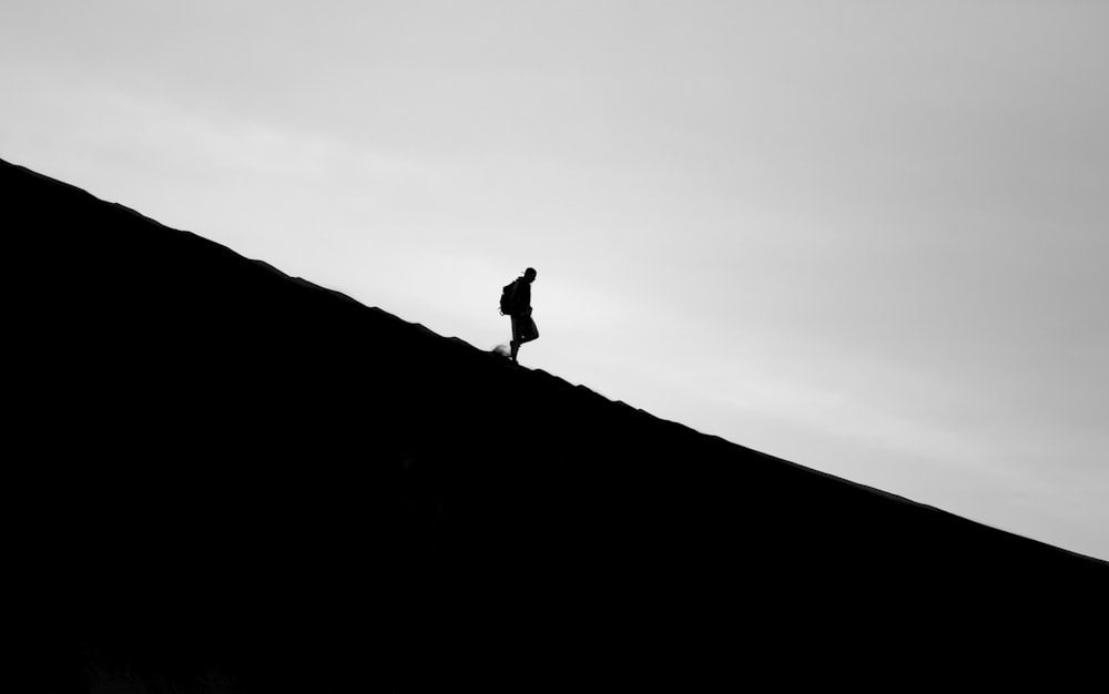 山の上を歩く人のシルエット写真