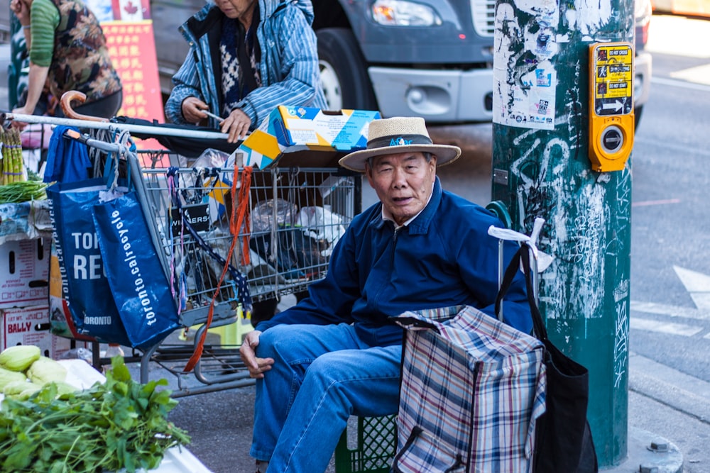 sitting man wearing black jacket and blue denim jeans