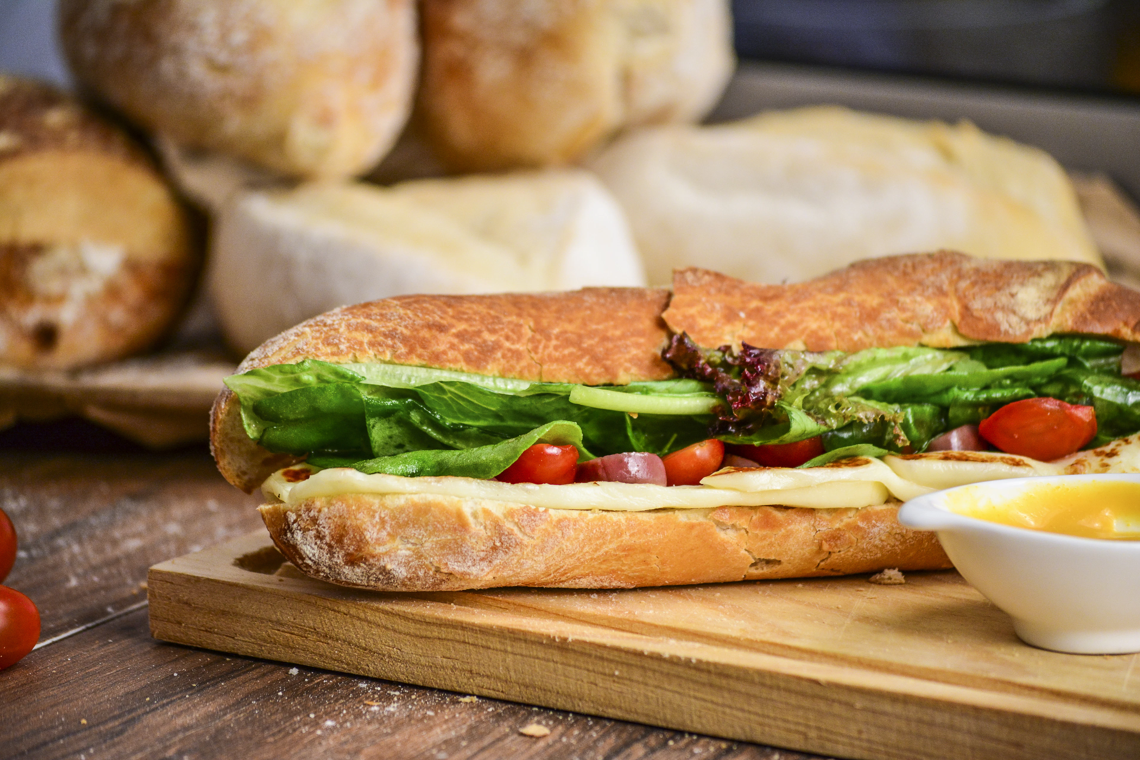 A crisp baguette sandwich on a wooden board