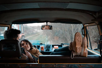 man sitting on bucket seat while woman on his lap