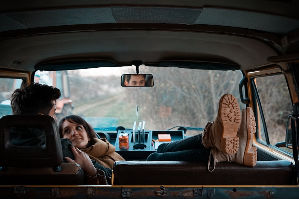 man sitting on bucket seat while woman on his lap