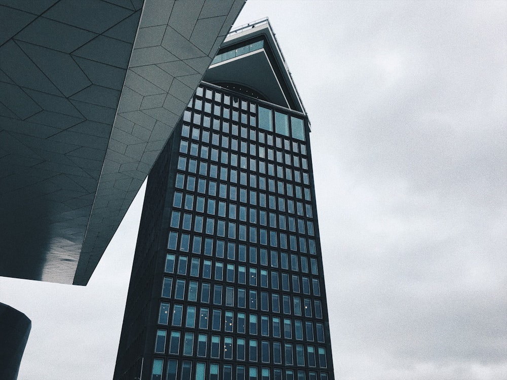 Foto de un edificio de hormigón negro con vidrio bajo el cielo nublado