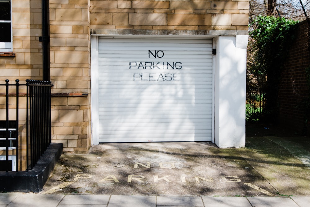 gray metal roll-up door with no parking please printed