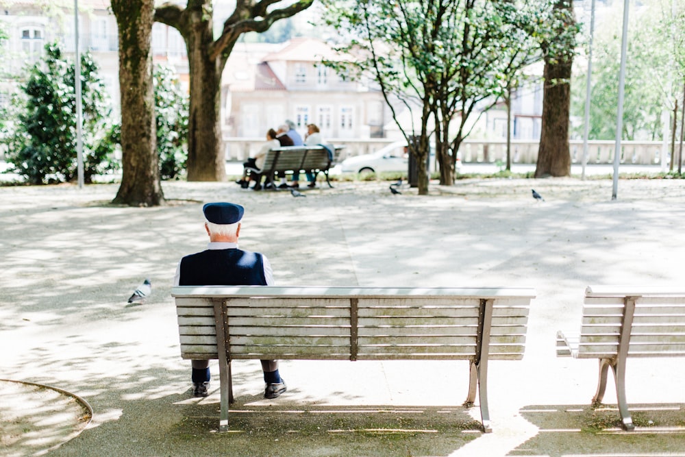 person sitting on beige street bench near trees photo – Free Bench Image on  Unsplash