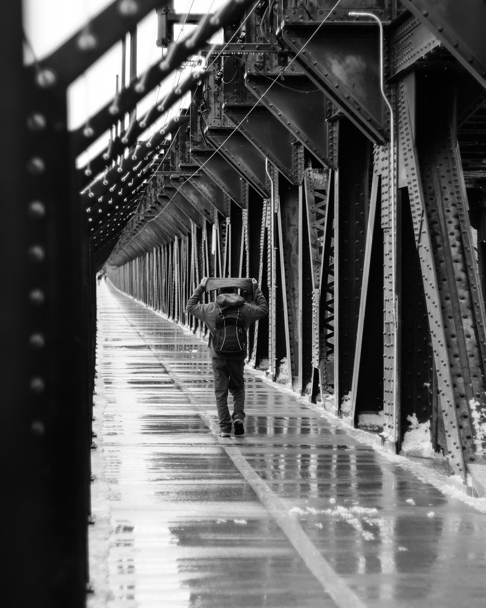 man walking on pathway while covering his head