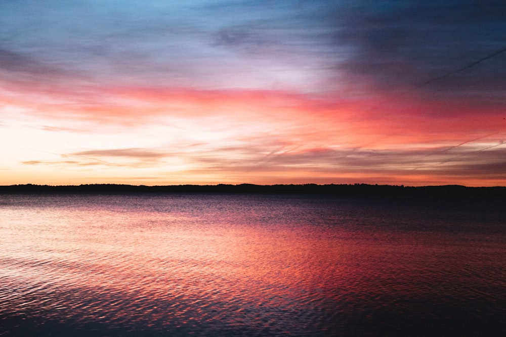 calm body of water during sunset photo