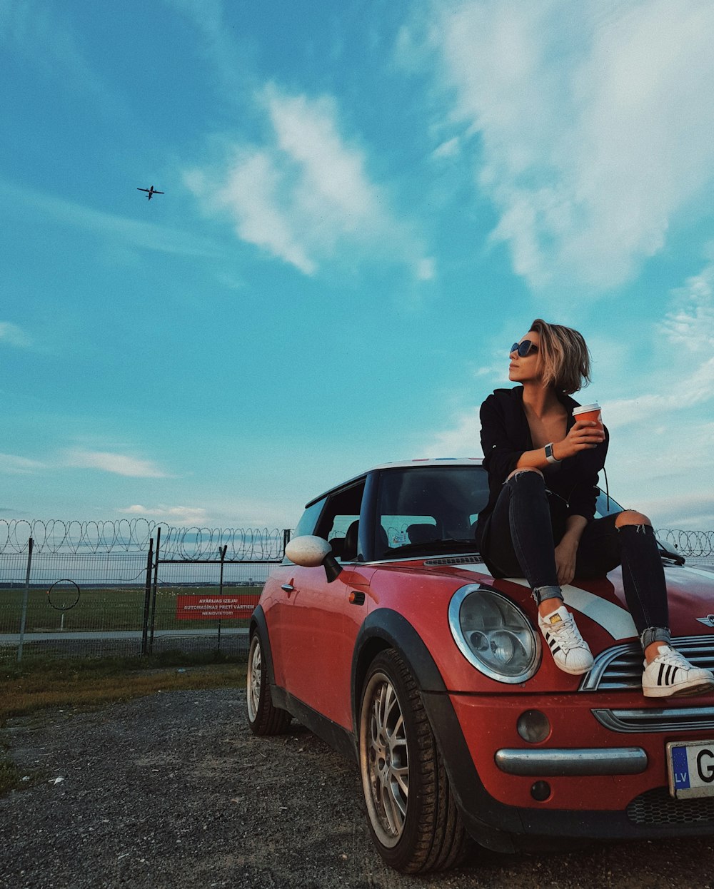 woman sitting on front of vehicle